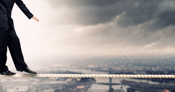 Person doing balance on edge of tall building