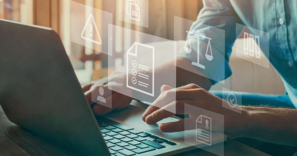 Person on laptop with compliance icons